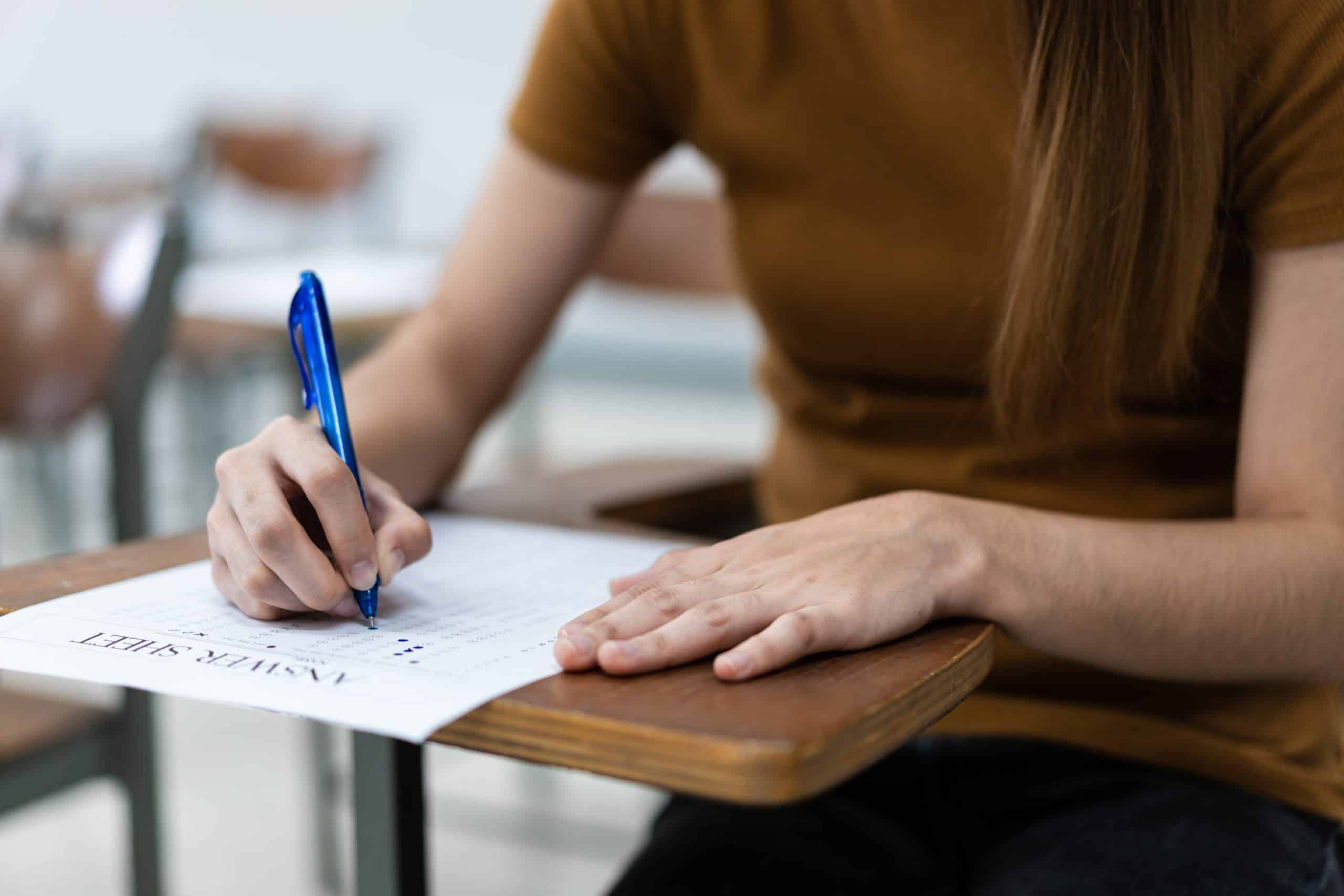 pessoa sentada em uma classe fazendo prova