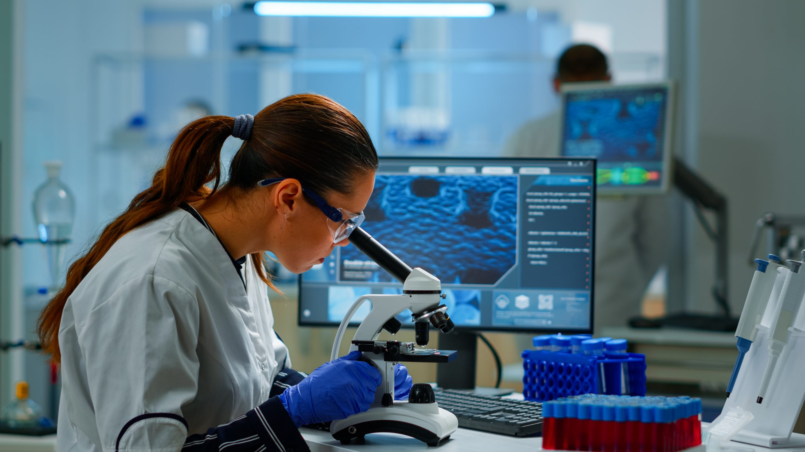 mulher olhando microscópio em um laboratório