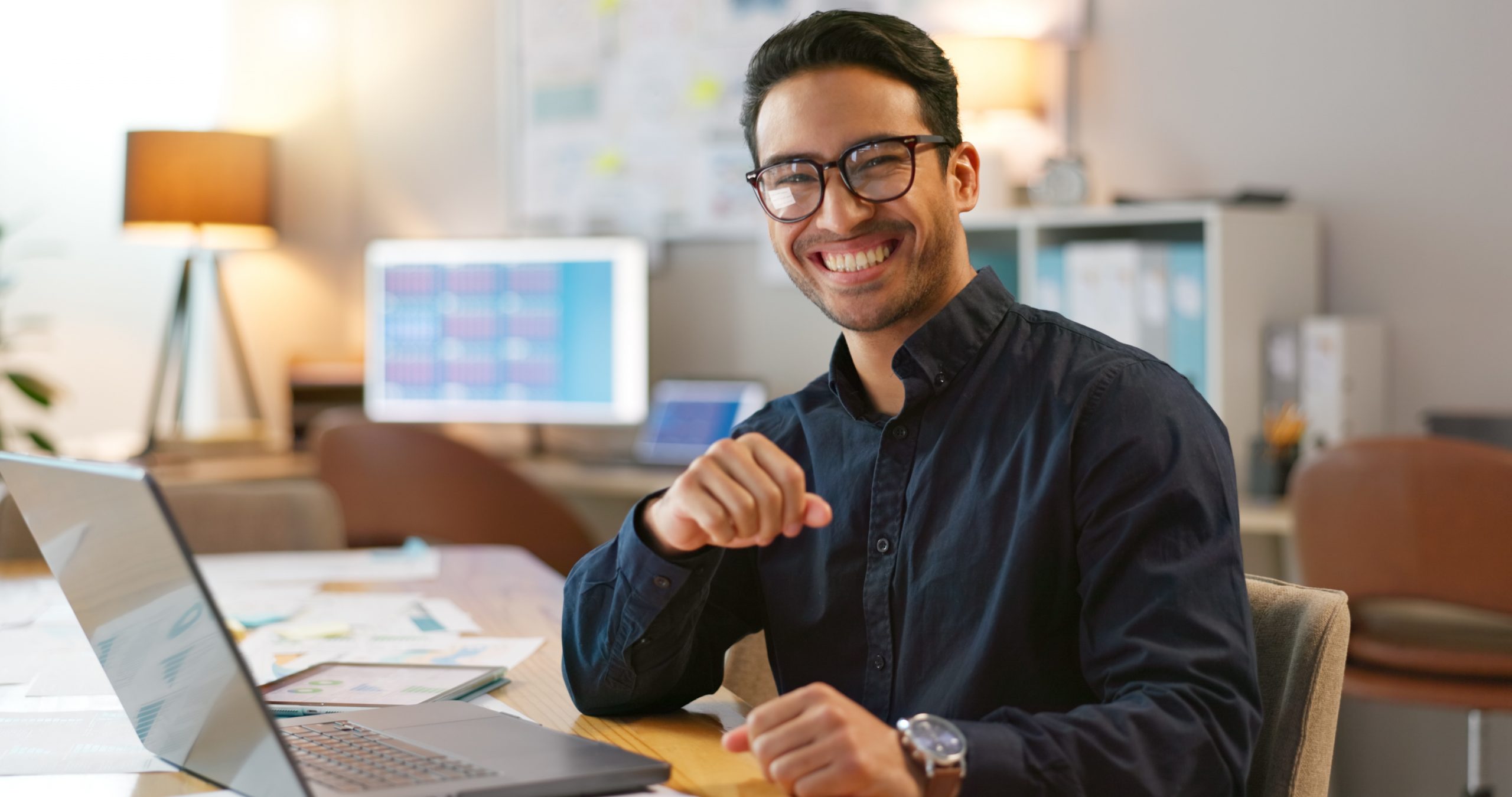 jovem adulto em ambiente de trabalho sorrindo para camera