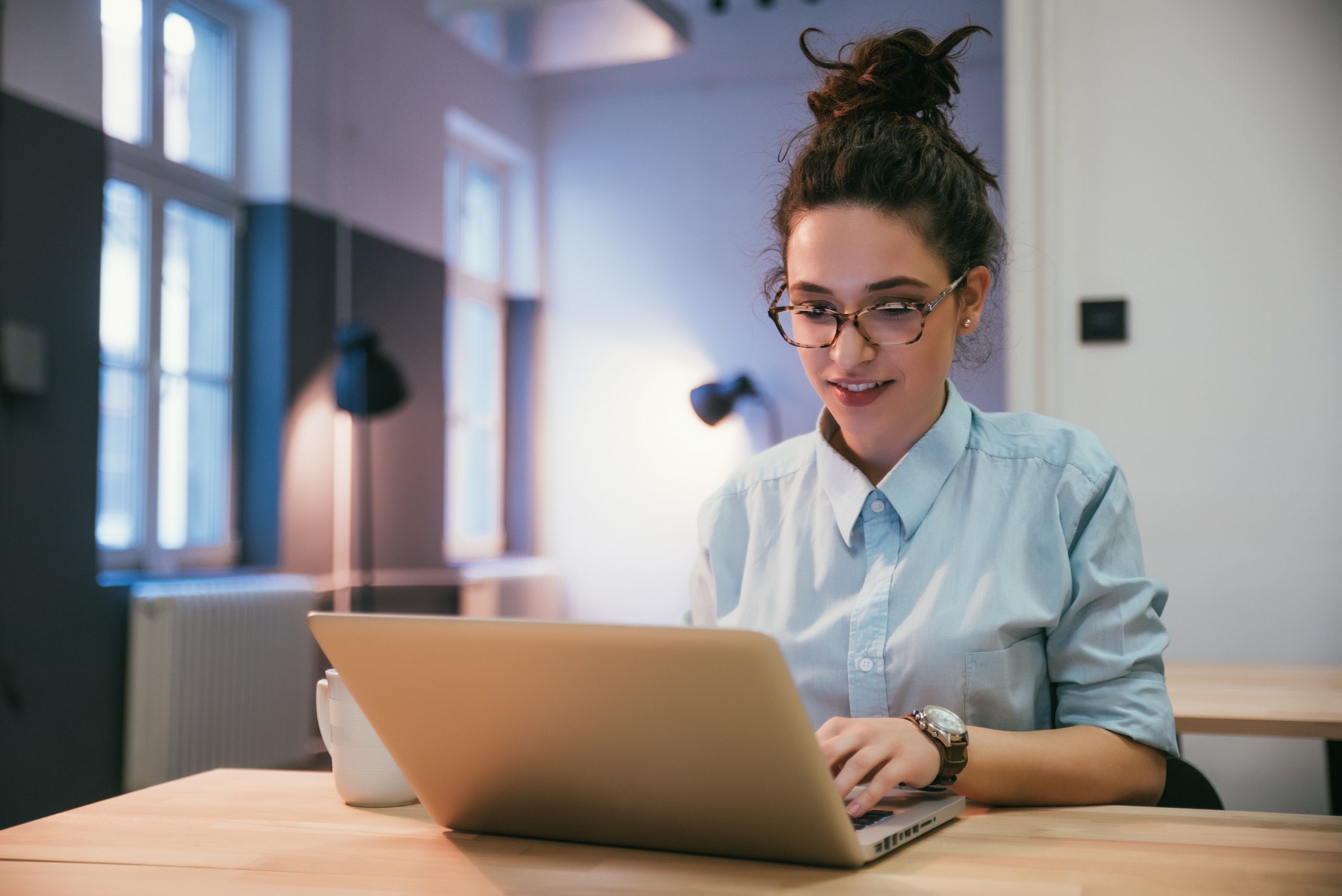 jovem adulta sentada mexendo em um notebook