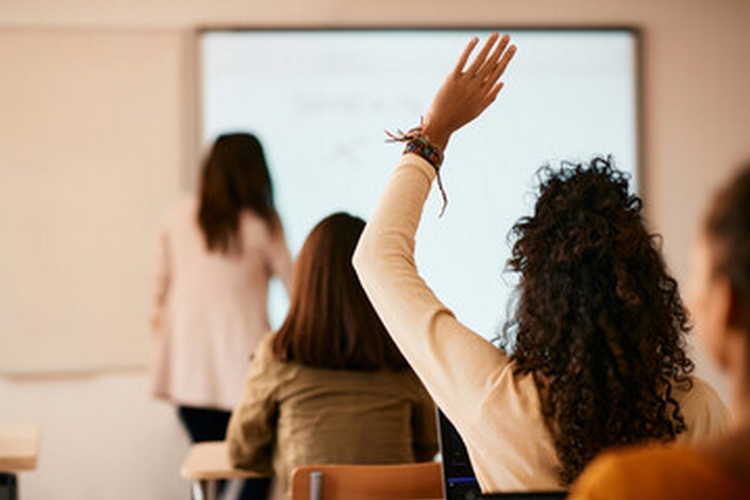 sala de aula com alunos sentados de costas para camera