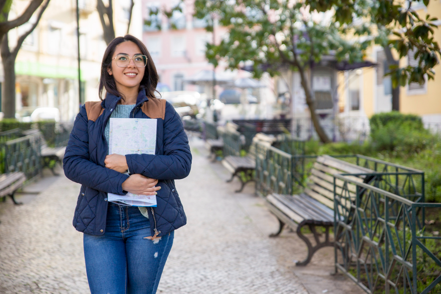 jovem adulta em pé na rua segurando cadernos Ela está sorrindo