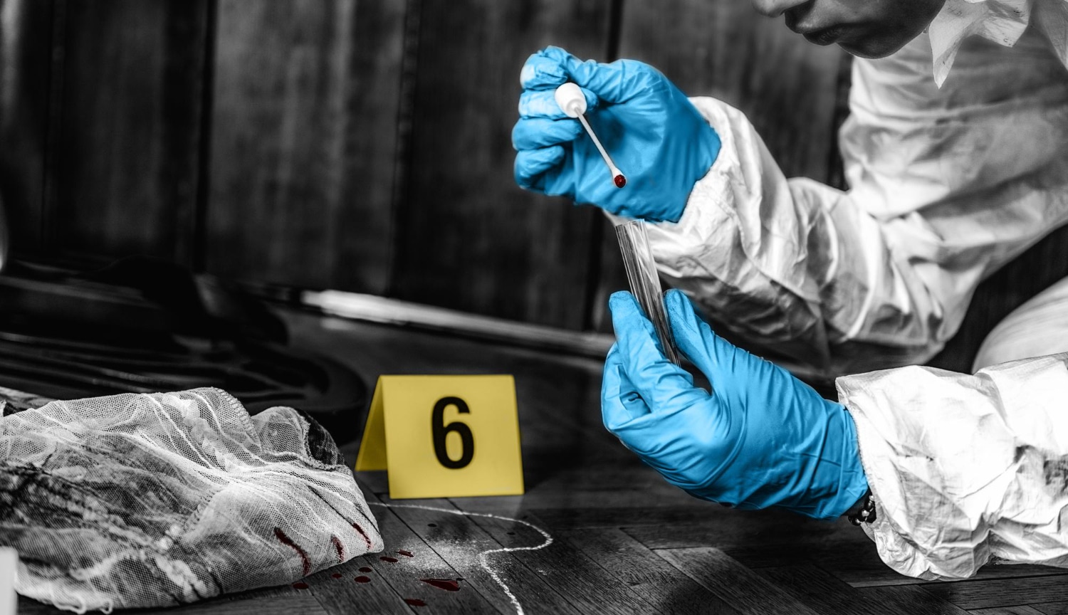 Investigador forense a recolher provas de sangue de uma cena de crime.
